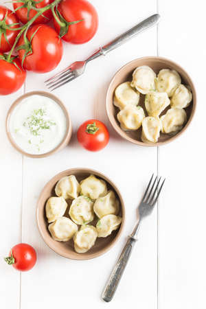 Top view: two portions of meat dumplings, ravioli with meat on white wooden backgroundの写真素材