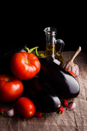 Contrast juicy vegetables: red tomatoes and eggplantsの写真素材