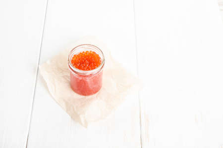 Red caviar in glass bowl on white wooden backgroundの写真素材