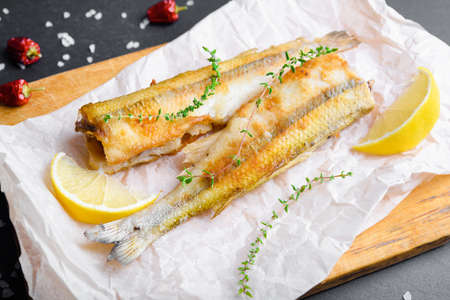 Fried smelts on bake paper with lemon
