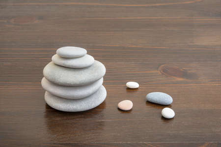 Pyramid of pebble stones for oriental spa massage on wooden planksの写真素材