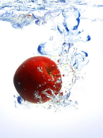 red apple under water with a trail of transparent bubbles.の写真素材