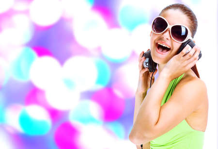  woman in green shirt and sunglasses listening for the music using headphones 