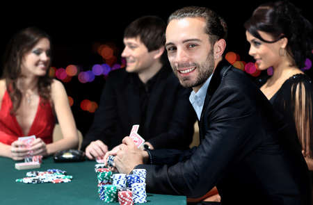 Poker players sitting around a table at a casinoの写真素材