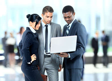 Happy business man holding a modern laptop computer with his team