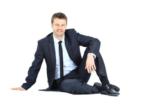 Portrait of business man sitting on the floor isolated over white background の写真素材