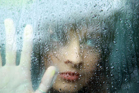 Sad young woman and a rain drops
