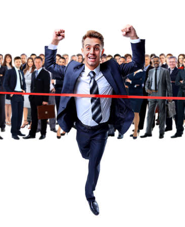 Happy businessman running through finishing lineの写真素材