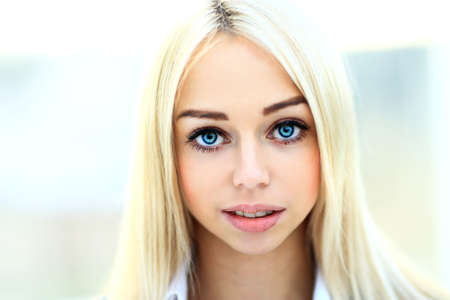 Beautiful woman with long straight blond hair. Fashion model posing at studioの写真素材