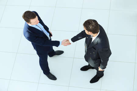Top view of a two businessman shaking hands - Welcome to businessの写真素材