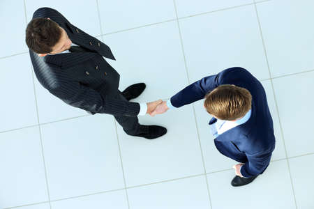 Top view of a two businessman shaking hands - Welcome to business