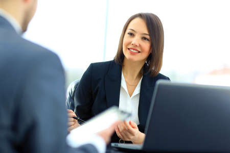 Beautiful young businesswoman conducting a job interview seated at her desk