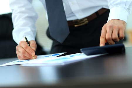 Businessman Using Calculator In Office