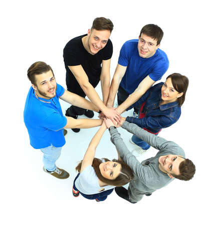 Top view of young people with their hands together in a circle.