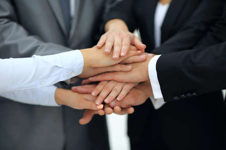 Close-up of business partners making pile of hands at meeting
