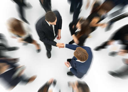 Two businessmen making agreement, their colleagues standing near byの写真素材