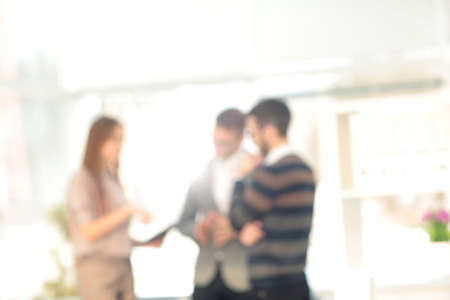 Blurred abstract background of business discussion people group. Blurry view inside office interiorの写真素材