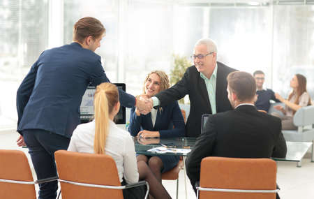 Business partners shaking hands after a successful transaction.