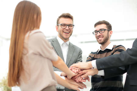 Close-up of business partners making pile of hands at meeting