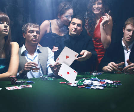 Poker players sitting around a table at a casinoの写真素材