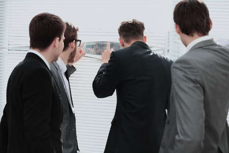 Business team looking through the office window, view from the back