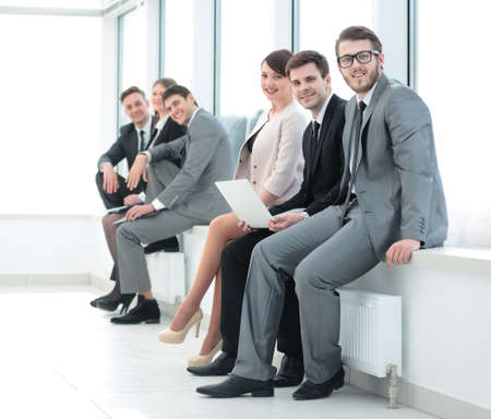 business team sitting on the windowsill in the new officeの写真素材