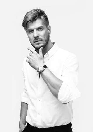 Black and white portrait of handsome man isolated on white studio background posing to the cameraの写真素材