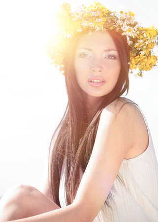 Romantic girl in a wreath of wild flowers in a field. Summer lifの写真素材
