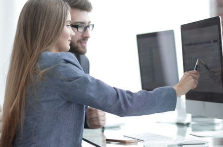 colleagues discussing information on a computerの写真素材