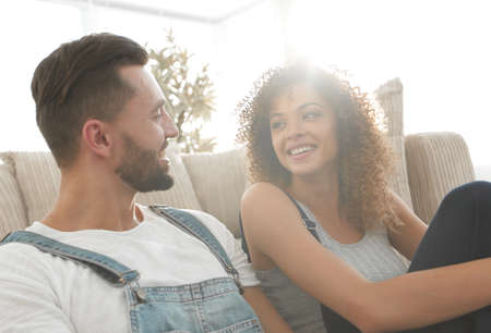 Newlyweds sitting on the couch in a new apartment.