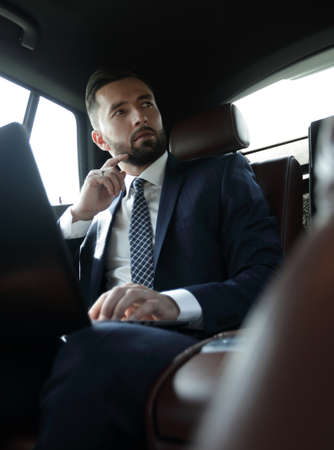 businessman working with laptop and looking out the window of aの写真素材