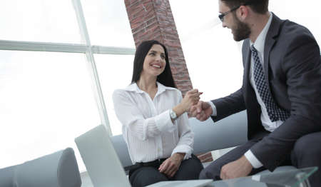 members of the business team show their success sitting at the desk.