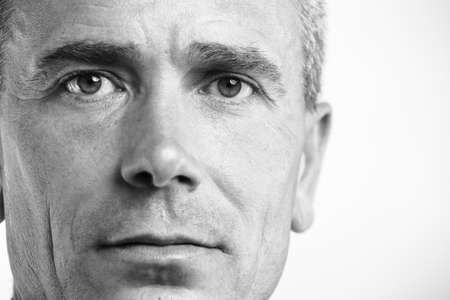 Portrait of successful  mature business man smiling against grayの写真素材