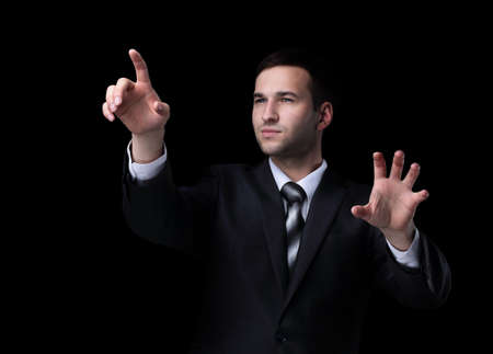 Business man pushing the imaginary  button. Isoladed on black.の写真素材