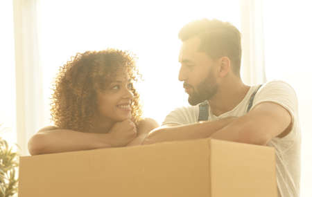 Portrait of the newlyweds near the box with things for moving.