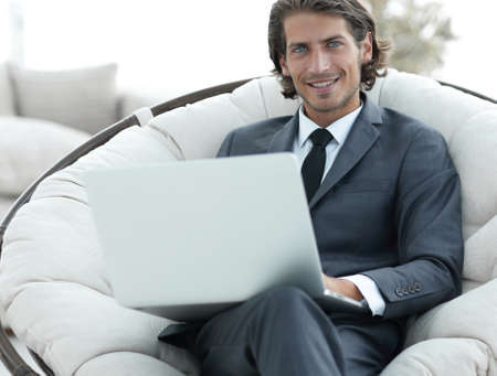 close-up of smiling businesswoman working with laptop in living room.の写真素材