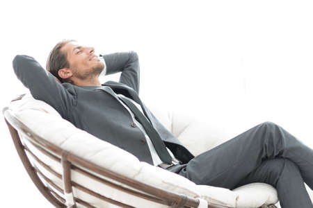 young businessman sitting in large comfortable armchair.の写真素材