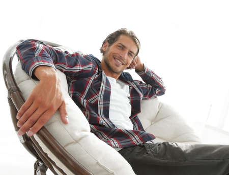 serious guy rests sitting in a large comfortable chair. side view.の写真素材