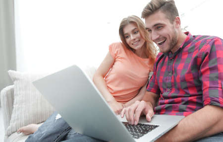 Happy modern couple surfing the net and working on laptop at homeの写真素材