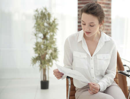 young business woman is reading a working paper.の写真素材