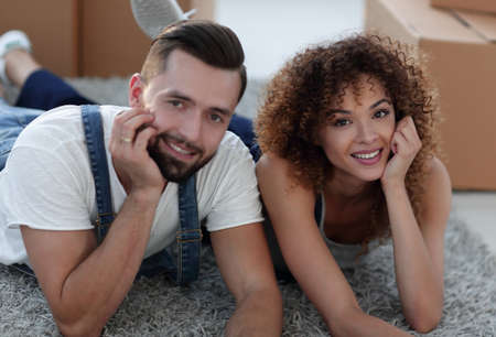 Portrait of a married couple lying on the floor after moving