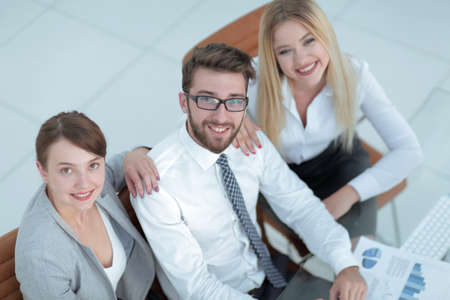 successful business team sitting at table and looking at camera.