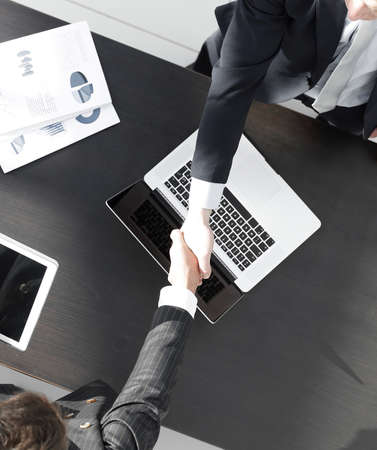 handshake of business partners above the Desk.