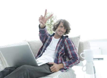 happy guy with a laptop showing a winning gesture. concept of success.