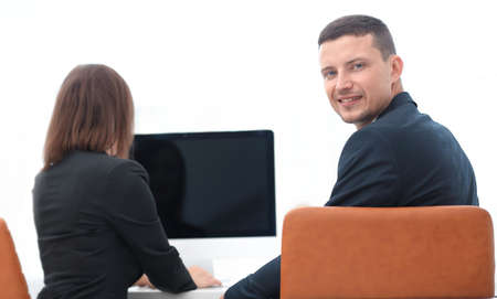 rear view. businessman sitting at Desk and looking at camera.