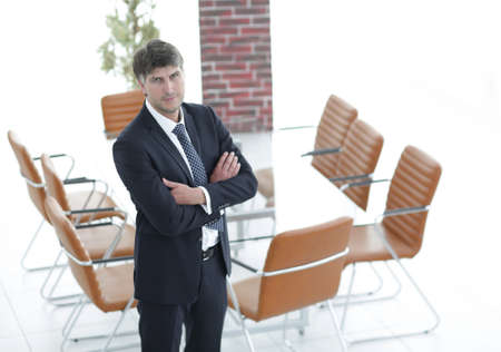 Business man standing in an empty meeting roomの写真素材
