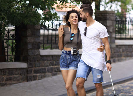 Cheerful young couple walking on urban streetの写真素材
