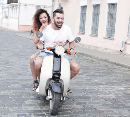Full length side view of happy couple riding on retro motorbikeの写真素材