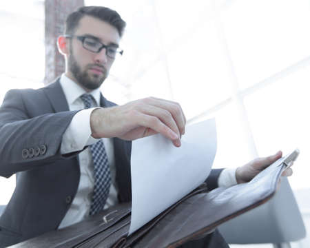 businessmans hand with suitecase in a modern officeの写真素材