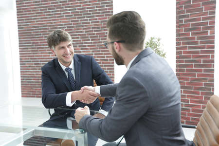 greeting handshake of colleagues at the deskの写真素材